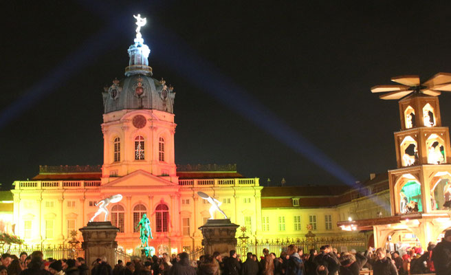 Weihnachtsmarkt vor dem Schloss Charlottenburg, das Schloss in orangem und gelbem Licht. Foto: Helga Karl 2014