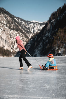 Schlittschuhlaufen am zugefrorenen Toplitzsee im Ausseerland mit Bergkulisse