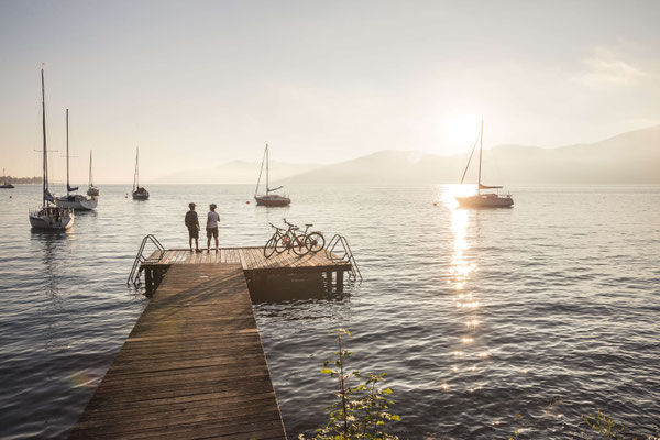 Holzsteg am Attersee mit Segelbooten und Abendlicht in der Sommerlandschaft