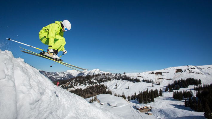 Skifahrer im Skigebiet Obertraun mit Blick auf die verschneite Dachsteinregion