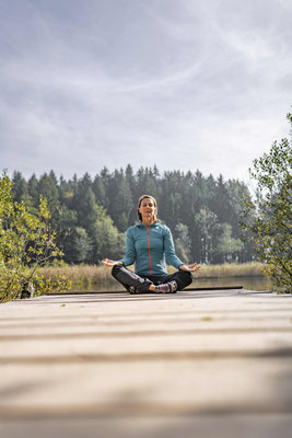 Person bei Meditation am Seeufer des Traunsees mit ruhiger Naturkulisse und Bergpanorama
