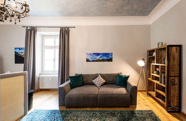 Gemütliches Wohnzimmer in der Ferienwohnung Bad Aussee mit Bücherregal und Sofaecke