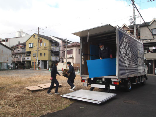 トラックから資材を降ろす作業