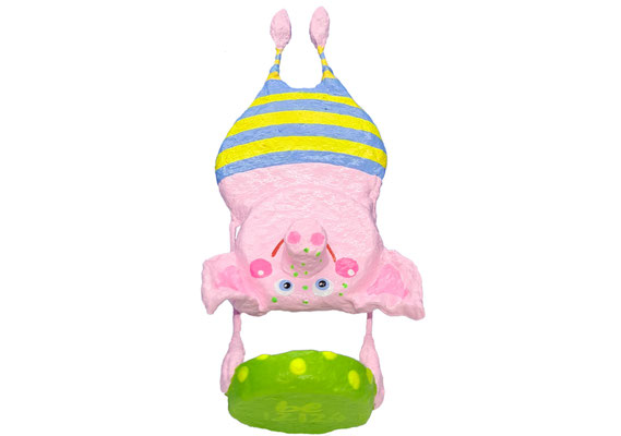 Handbemaltes, rosa Pappmaché-Schwein im Handstand, ein origineller Glücksbringer mit gelb-hellblauen Streifen.