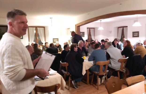 Volle Gaststube im Vordergrund Wahlleiter Markus Göschl