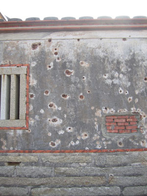 Bullet holes in the stone wall