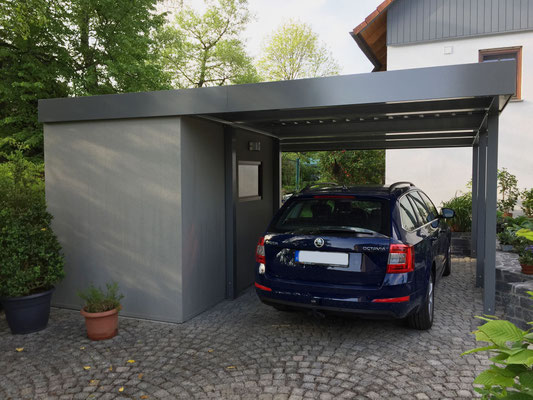 Beispiel-Nr. ST-16  Einzelcarport mit seitlich gestellter Anbaukammer mit Dekorputz-Glattwänden. Die Kammer erhält zusätzlich ein Fenster aus dem umfangreichen Zubehörprogramm für Stahlcarports.