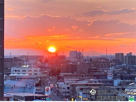 噴気をあげる浅間山と落日