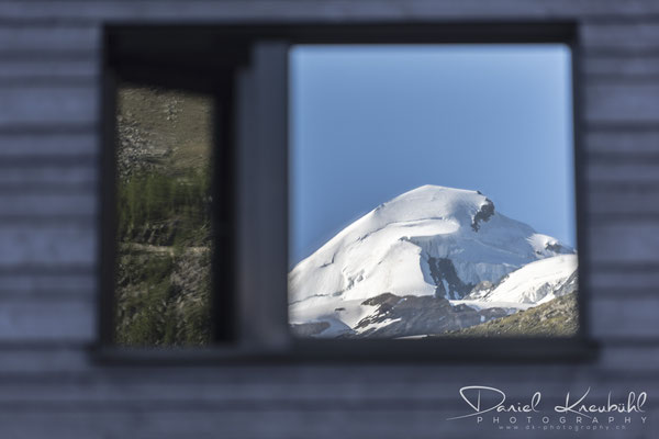 Allalinhorn spiegelt sich im Fenster des Aqua Allalin