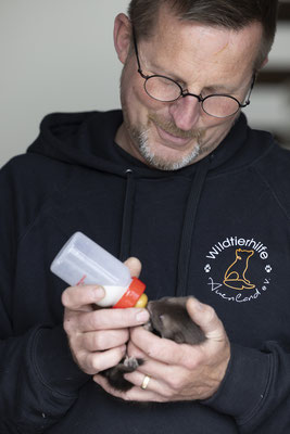 Marcus Moos füttert ein Steinmarderbaby mit der Flasche.