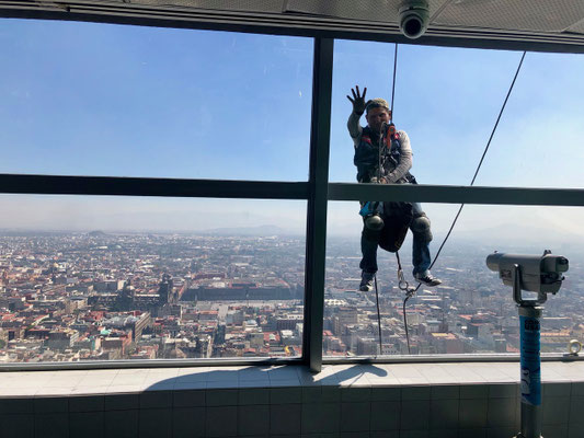 The window cleaner hanging in a normal climbing rope 300m above Mexico City in the Torre Latino