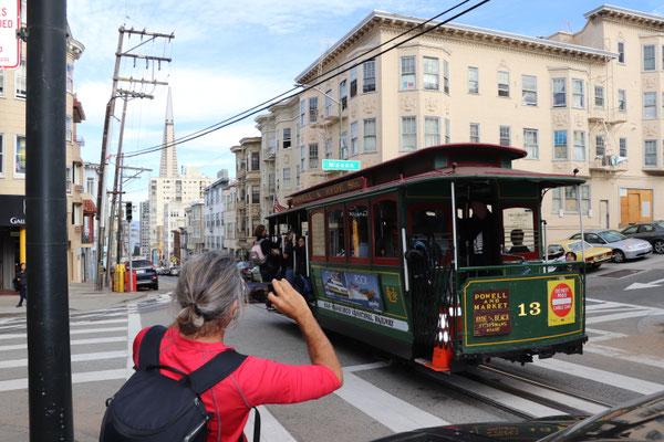 The cable car is hooked to a steel rope between the tracks and invisible to pedestrians...very clever design