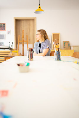 Porträt einer jungen Frau in Kunst Schule am Tisch sitzend