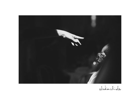 Deutende Hand in Lichtschein vor schwarzem Hintergrund. Künstlerisches Schwarz Weiss Foto von Sebastian Schieder, Fotograf Regensburg.