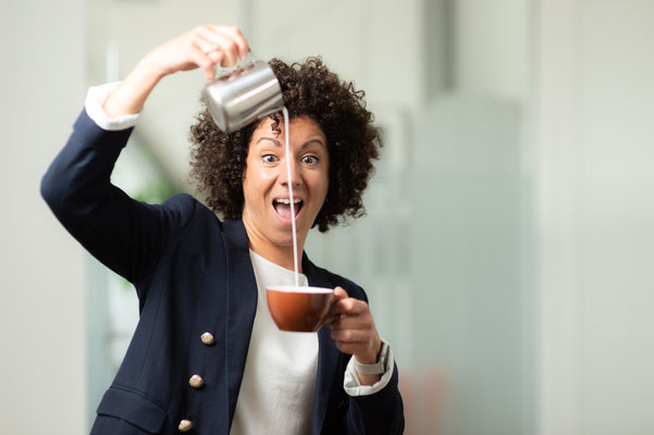 Frau beim einschenken von Milch in eine Kaffee Tasse. Business Porträt aufgenommen von Sebastian Schieder, Fotograf Regensburg.