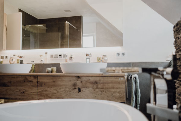 Design Waschtisch aus Eiche mit Aufsatzwaschbecken und an der Wand hängend in einem Badezimmer mit Betonfliesen