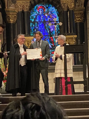 ThP 230529 Maastricht - Onze Lieve Vrouwebasiliek - De voorzitter van de Broederschap met directeur Marco van Baalen van het KIEN en pastoor Jan Vries met het Certificaat van de Inschrijving van 'De Bidweg' in het Immaterieel Erfgoed Nederland.
