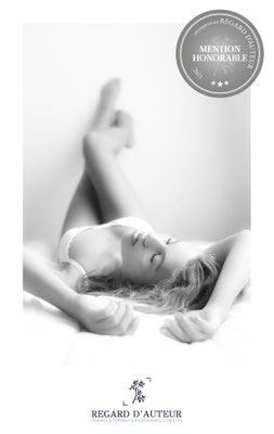Photographie artistique de Katia allongée, un portrait en noir et blanc tout en délicatesse récompensé pour sa composition épurée.