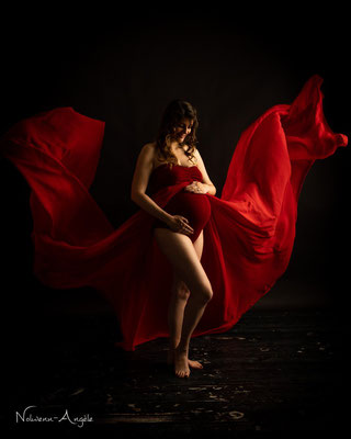 Photo d'une séance grossesse robe de créateur rouge accompagnée de voilage - Shooting réalisé au studio Danimages dans le sud de l'oise aux portes du val d'oise
