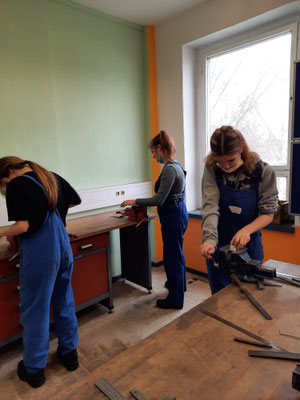In der Werkstatt wird ein Metallwürfel geschiffen.