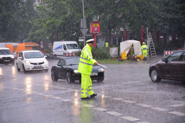 27- Polizist regelt straßenverkehr, Regen