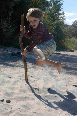 16- Junge springt am Strand