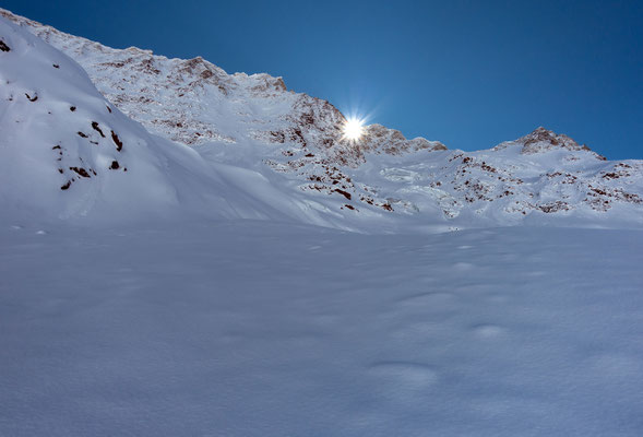 Der erste Sonnenstrahl kommt über den gezackten Verbindungsgrat vom Breitlauihorn