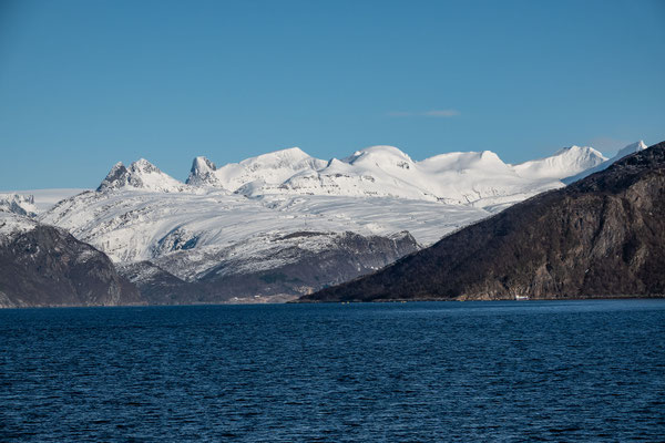 Auf der Fähre von Kilboghamn nach Jektvika leuchten die vorgelagerten Gipfel des Svartisen in der Abendsonne
