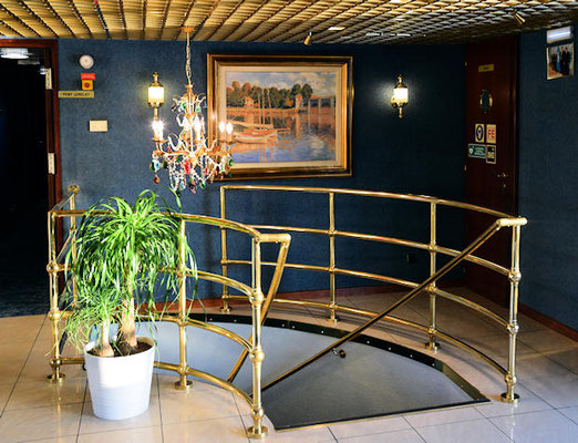 Espace réception - escalier de communication pont supérieur pont principal - A la cloison une reproduction du peintre Claude Monet : Le pont d'Argenteuil