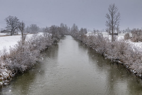 Ein Fluss fließt durch eine verschneite Landschaft