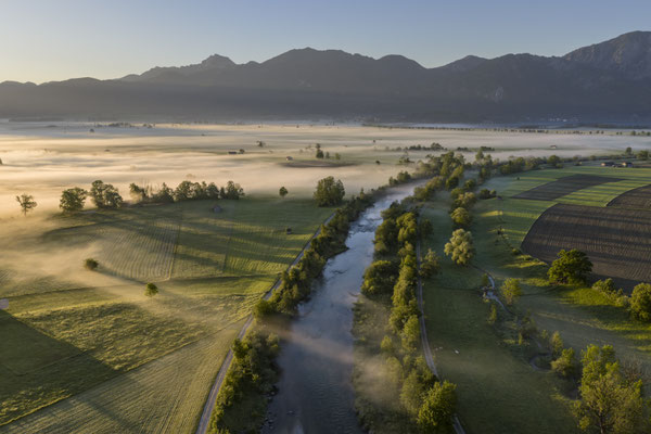 Fluss vor Bergen aus der Luft im Morgenlicht
