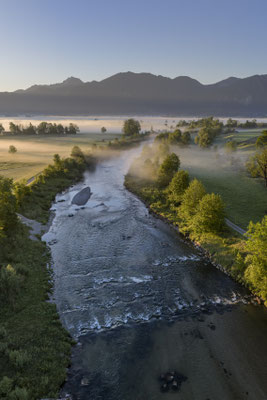 Fluss vor Bergen aus der Luft im Morgenlicht