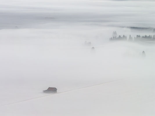 Nebel und Hütte im Schnee