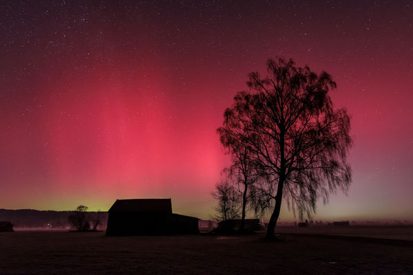 Nordlichter über einer Holzhütte