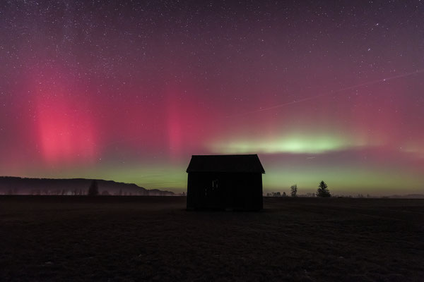 Nordlichter über einer Holzhütte