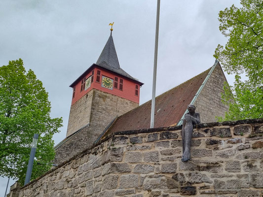 © Traudi - Wehrmauer um die Kirche mit sitzender Frauenskulptur