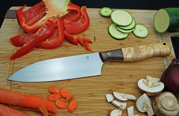Ein Chefmesser für die Küche mit einem Griff aus kaukasischem Nussholz und karelischer Maserbirke.