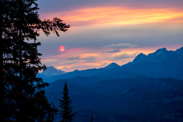 Die untergehende Sonne hat es schwer, durch die Rauchwolken der Waldbrände