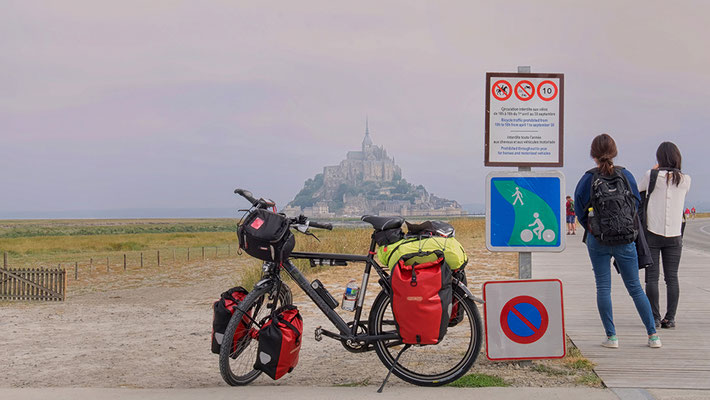 Rad und zwei Touristen vor Mont St. Michel Frankreich