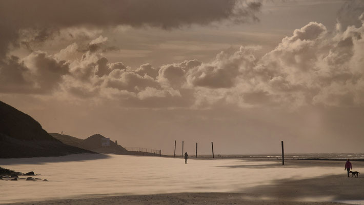 goldfarbener Sandsturm mit Wolken am Strand Wangerooge Deutschland