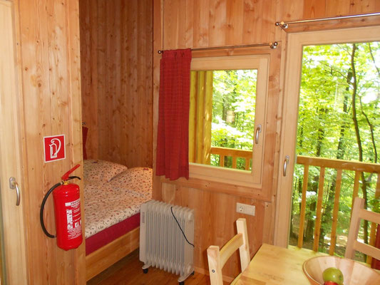 Innenraum des Baumhauses Freiraum mit Blick auf das Bett