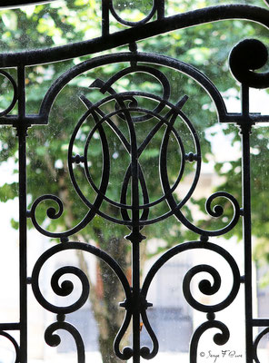 Détail de la porte d'entrée en fonte ouvragée et aux initiales du Médicis Palace à La Bourboule - Auvergne - France