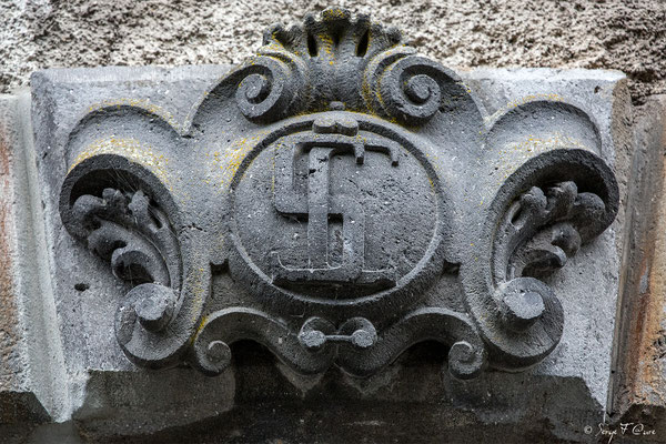 Détail des initiales du fronton de la porte d'entrée sculpté dans de la pierre de lave de l'ancien Médicis Palace à La Bourboule - Auvergne - France