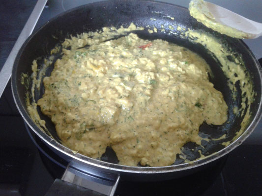 Tomatenwürfel, Schmand, Gewürze mit 50ml Wasser und Hefeflocken und Kräuter hinzugeben und immer wieder umrühren, bis die Masse fluffig und etwas fest wird. 