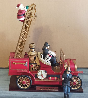 Mr Christmas. Camión de bomberos "Our heroes". Con música y movimiento. Sale luz del radiador. 15 canciones clásicas y villancicos. Santa y bombero intercambiable. 