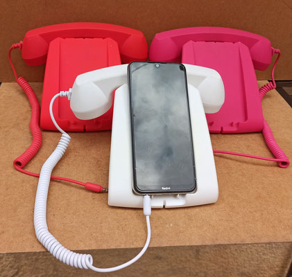 Soporte de goma con forma de teléfono de sobremesa para cargar y depositar el teléfono móvil. Se puede conectar al móvil el auricular.