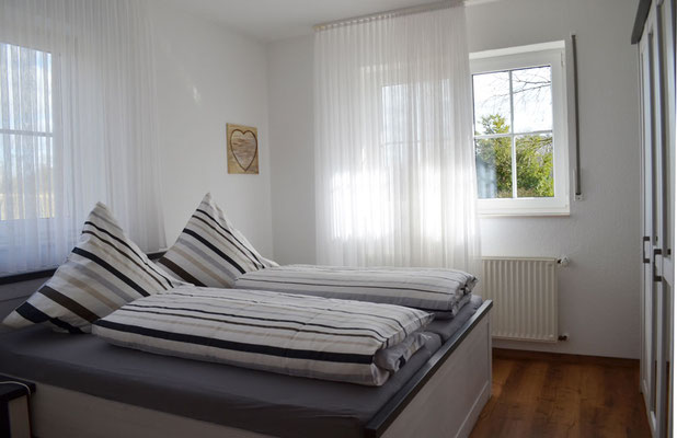 Helles Schlafzimmer der Ferienwohnung Olli mit großem Doppelbett (180x200 cm) – RUHE. NATUR. ERHOLUNG. in Westerkappeln.