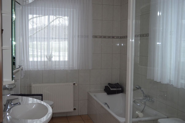 Badezimmer mit Badewanne inklusive 2 Haltegriffen, WC und zwei Fenstern für viel Tageslicht in der Ferienwohnung Olli.