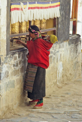 Woman with a baby on her back rolling the prayer wheels, Tashilhuenpo Monastery, Shigatse, Tibet 1993