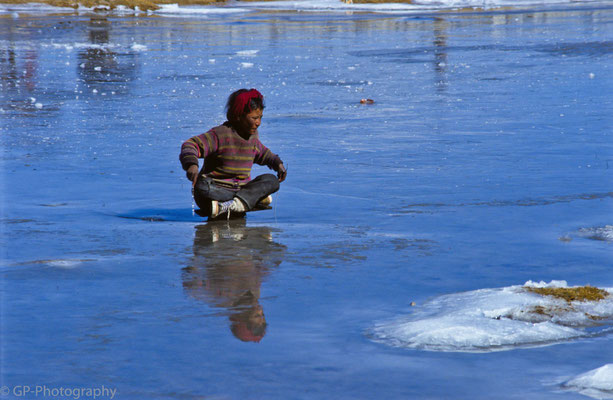 Little boy playing on a frozen pond in Old Tingri, Tibet 1993